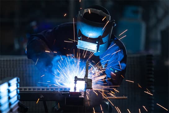 A worker operating a welder